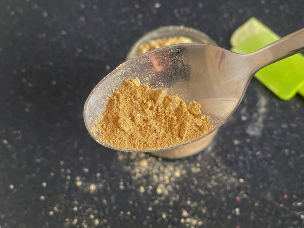 spoon with coconut sugar icing sugar in front of jar of coconut icing sugar