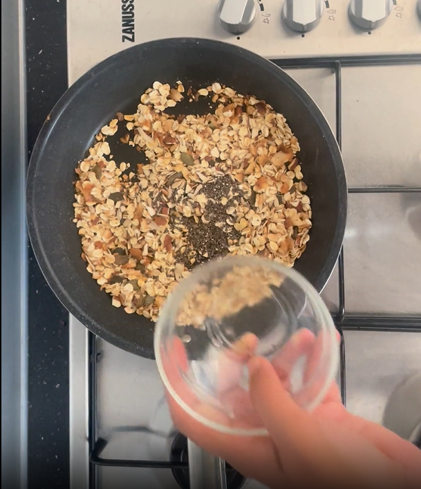 Adding chia seeds to toasted ingredients in hot non-stick frying pan