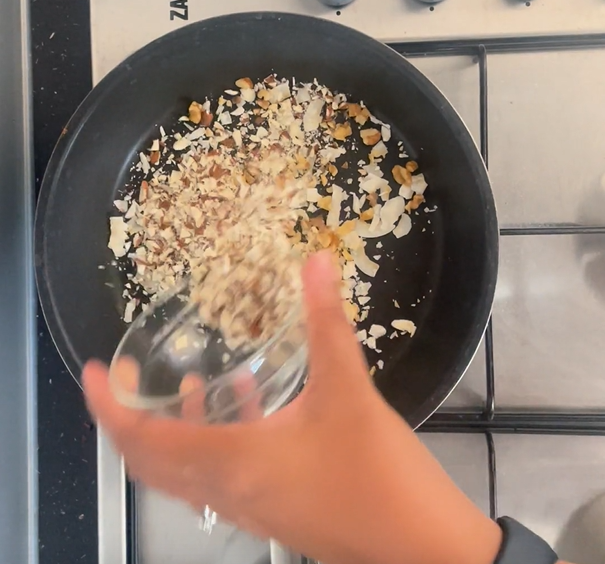 Adding chopped almonds to hot non-stick frying pan