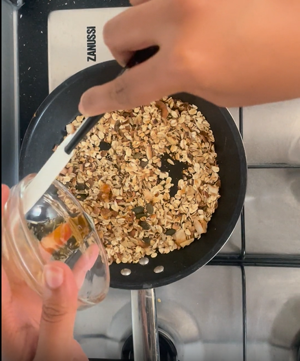 Adding maple syrup to toasted ingredients in hot non-stick frying pan