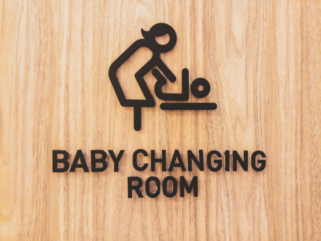 Baby changing room sign on wooden door