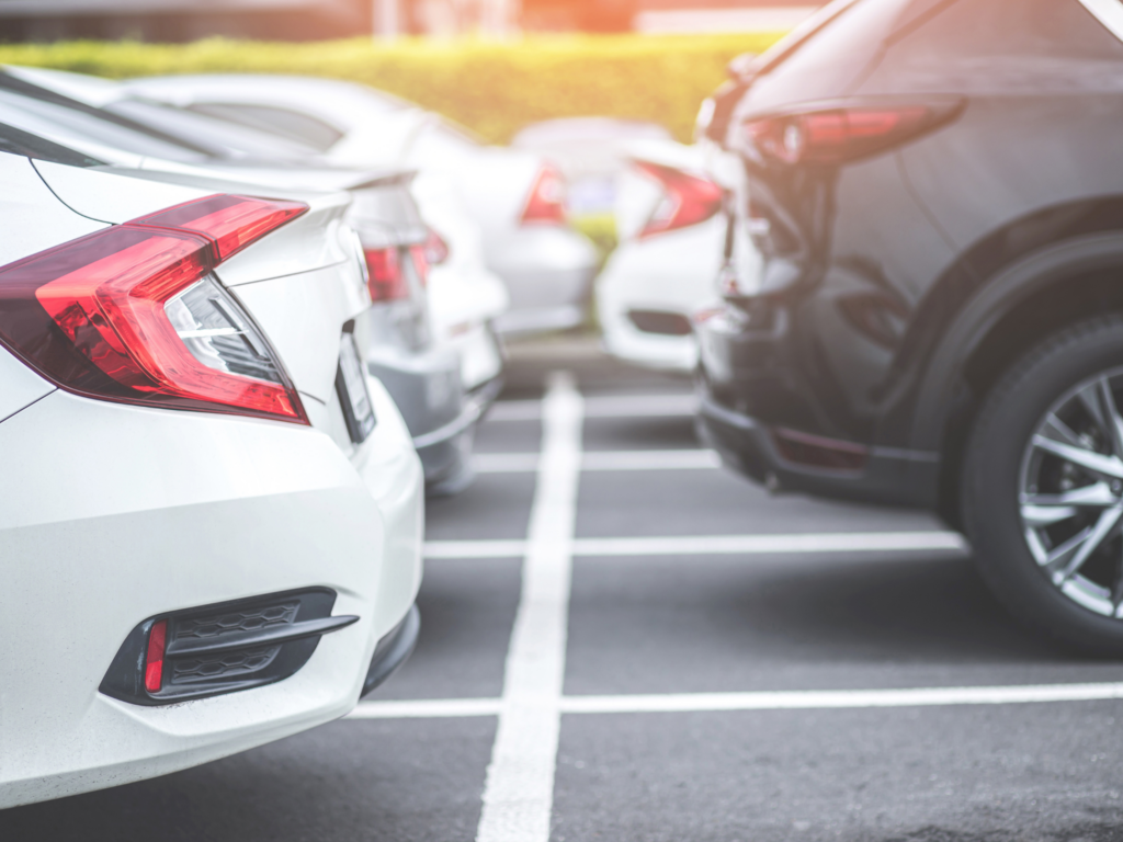 the back of 2 rows of cars parked in a parking lot