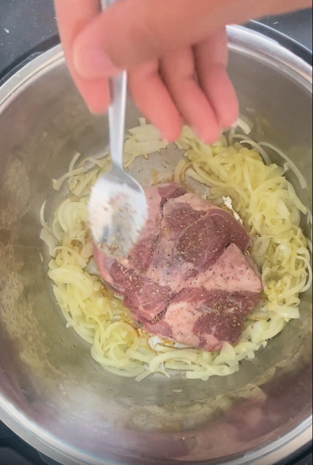 Adding mixed herbs to unseasoned side of lamb that is in the Instant Pot