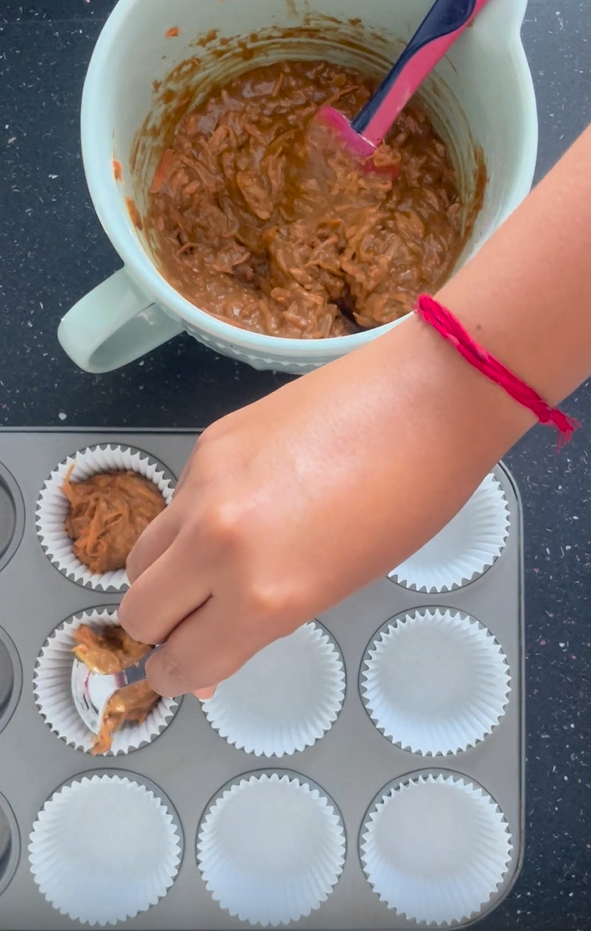 Filling muffin tray with carrot cake muffin batter