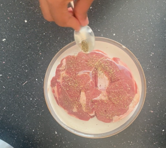 Seasoning lamb with mixed herbs on saucer