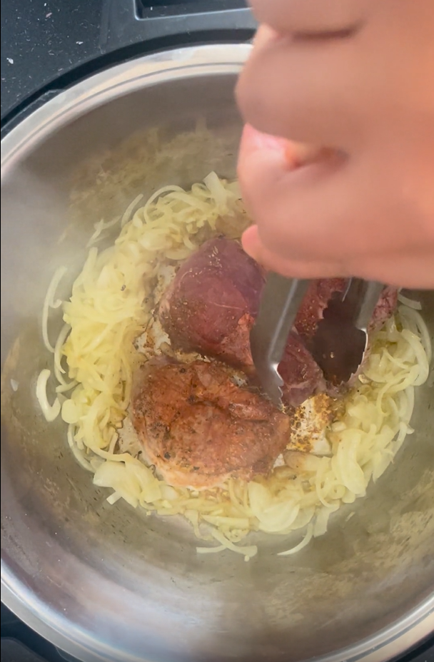 Turning over the lamb to show nicely browned and sealed lamb